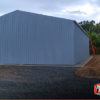 Commercial metal garage building with one roll-up garage door on the side.