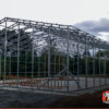 Commercial metal garage building framing on a concrete foundation with ladders laid inside.