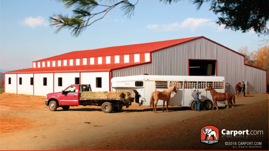 Commercial metal building with ridgeline styled panels, and trailer with horses in the foreground.